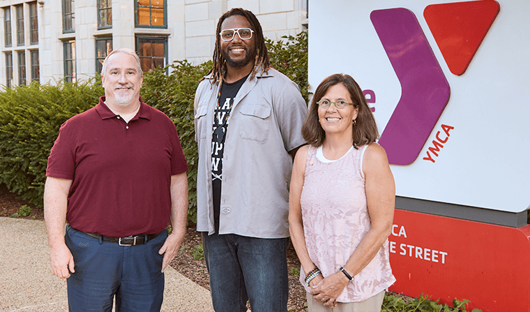 Three new Y board members standing in front of YMCA sign