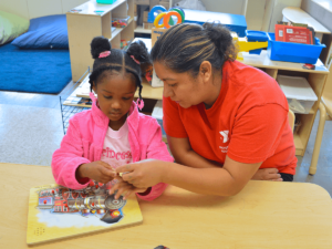A child sitting with a teacher at a table