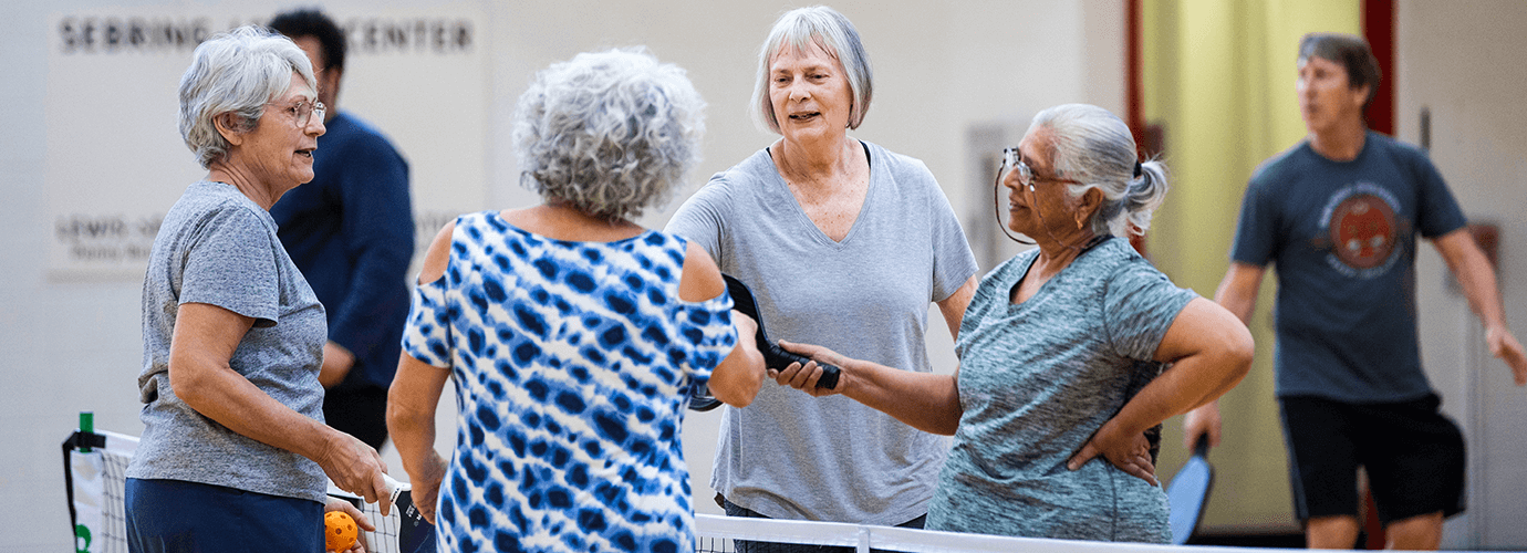 A group of older adults enjoying a game of pickleball.