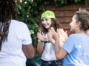 Young people standing in a circle clapping