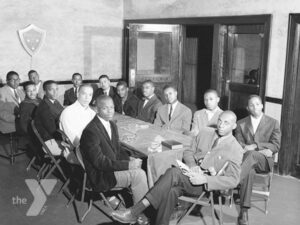 A group of Black men meeting around a table.