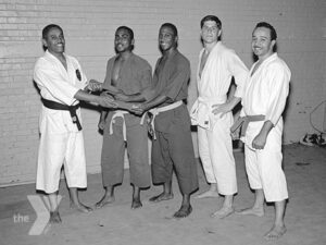 A group of five men posing in Judo uniforms.