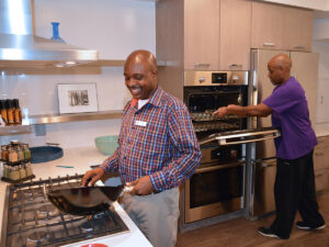 Two people cooking in the YMCA kitchen.