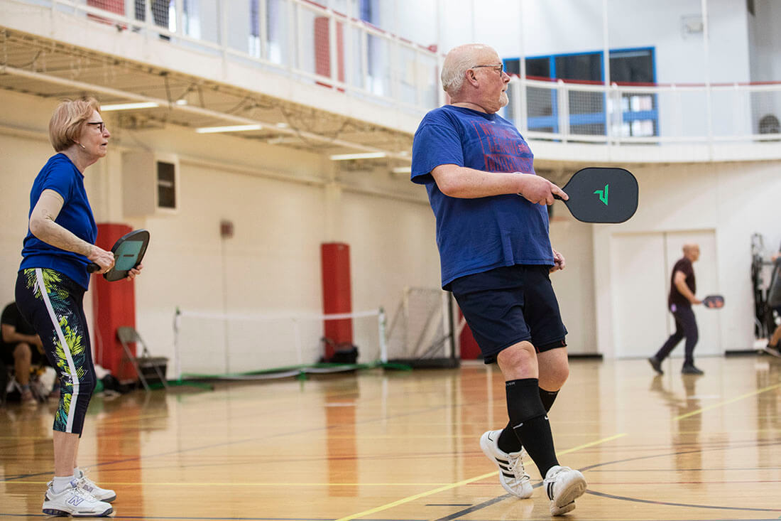 Two people playing pickleball at the YMCA.