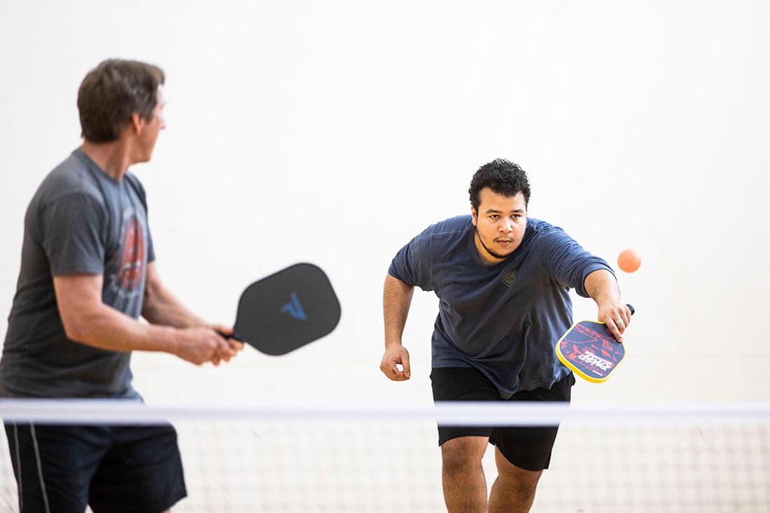 Two people playing pickleball at the YMCA.