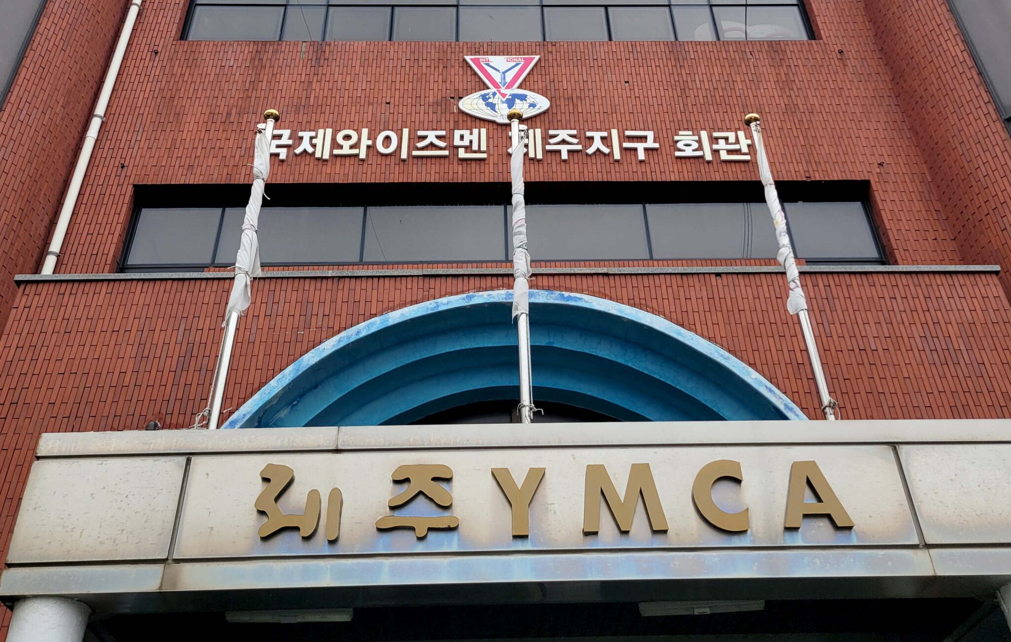 Image shows the brick facade of a building with Korean signage including "YMCA."