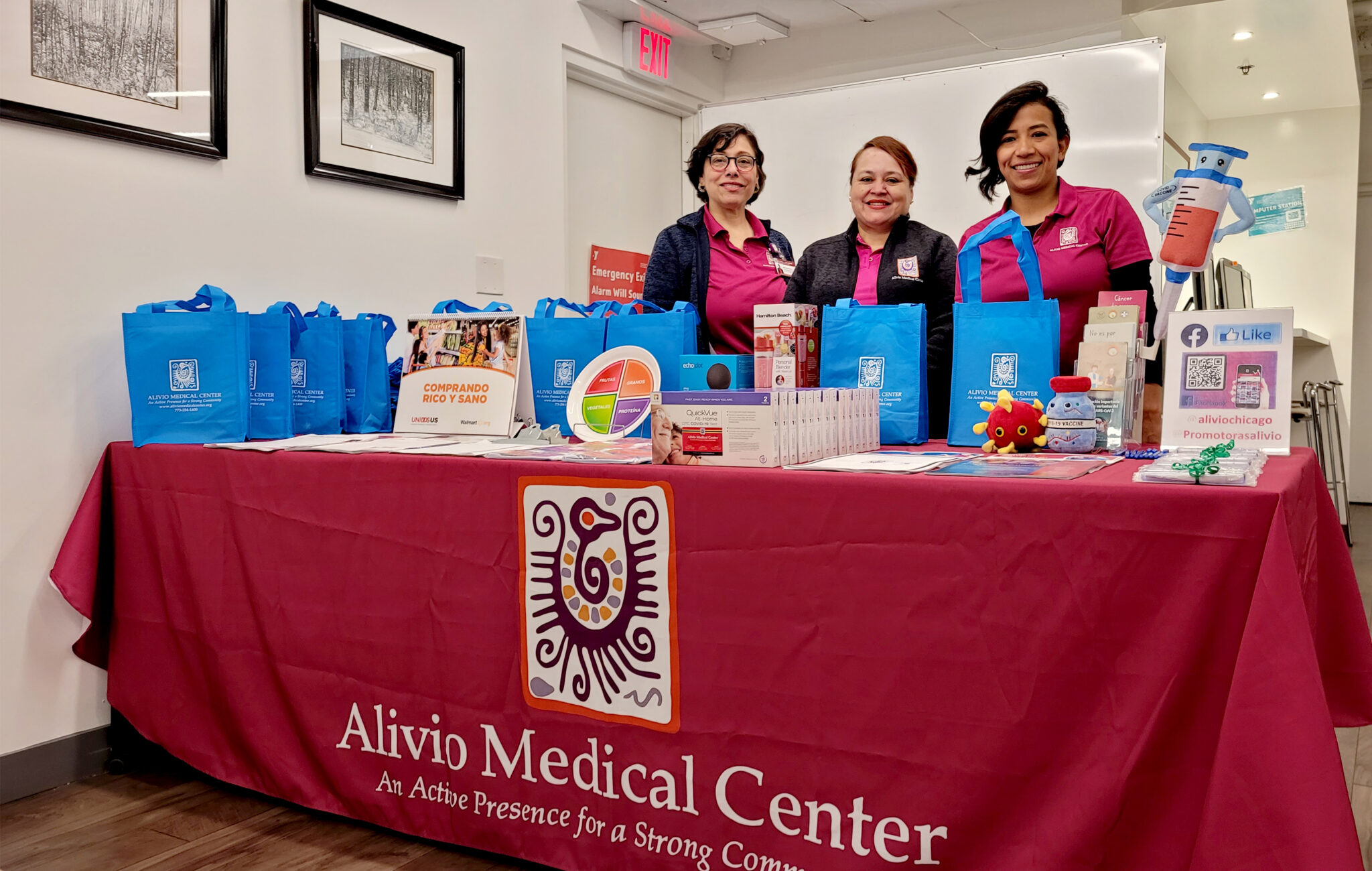 Employees from Alivio Medical Center standing behind a table