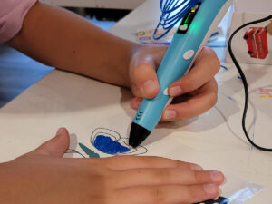 Meta Meets Camp kid at McGaw YMCA using 3D printer pen.