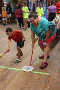 An adult and a child competing in a race at Family Camp Carnival.