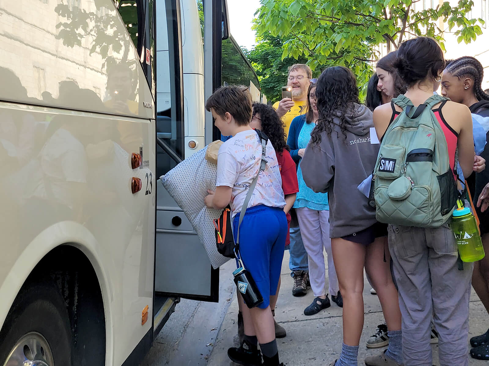 Several campers getting on the bus.