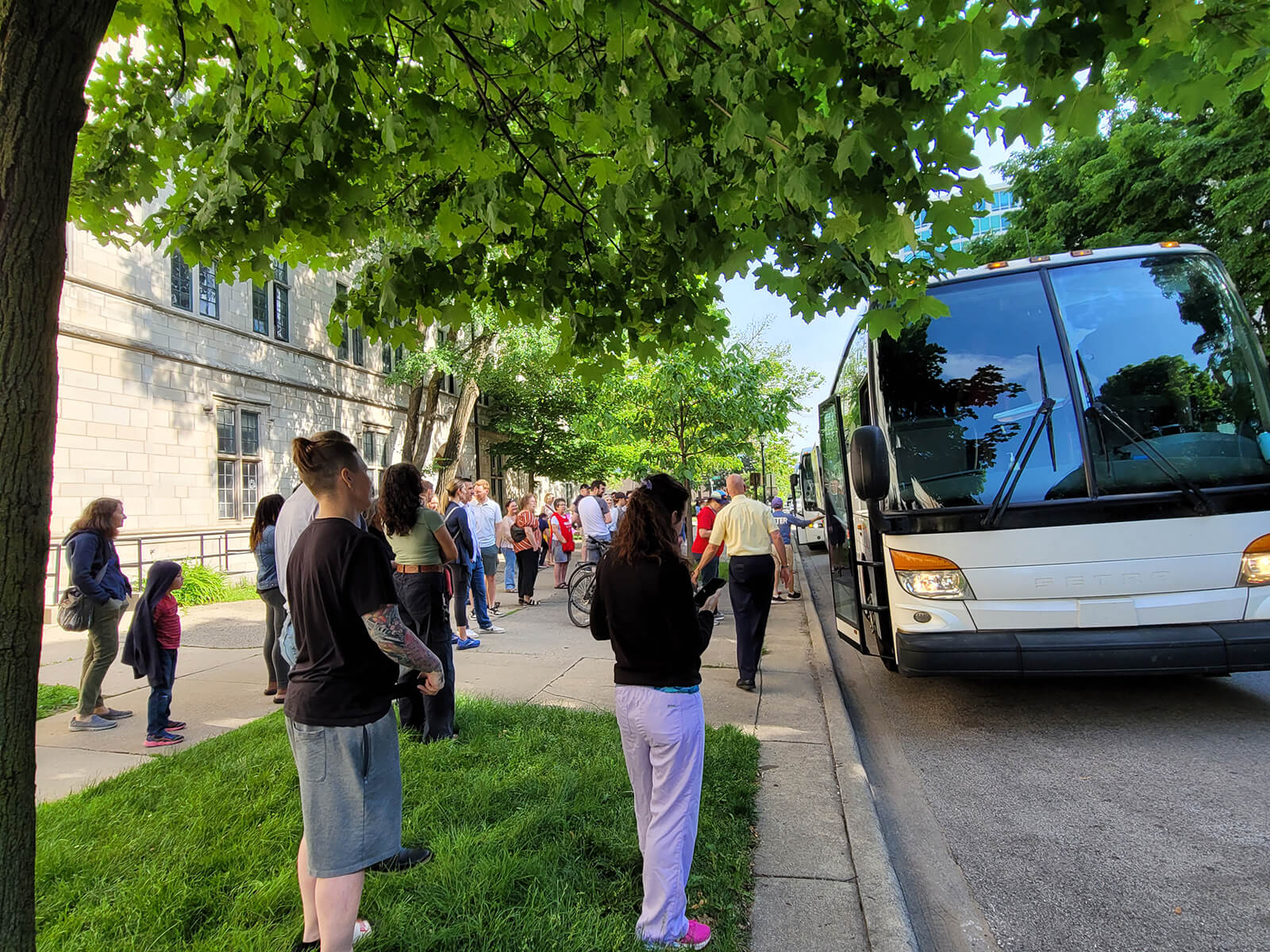 A group of adults standing in front of the Camp Echo buses.