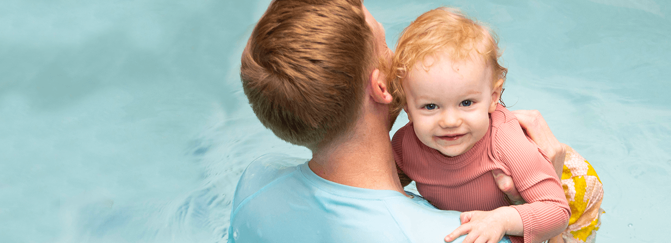 A child in the YMCA pool with their parent.