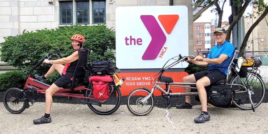 Mark and Noreen are sitting on their bikes in front of the Main Building.
