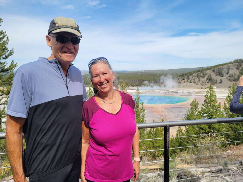 Two people standing above Grand Prismatic Spring at Yellowstone National Park