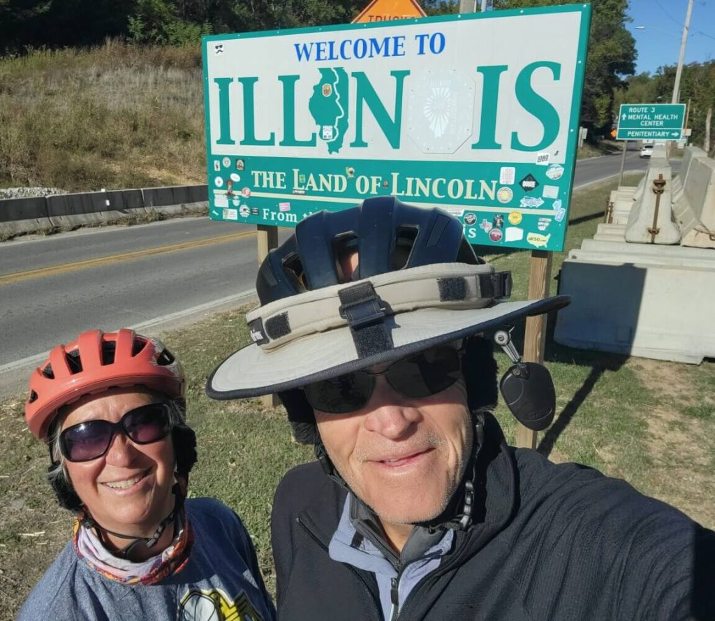 Mark Metz and Noreen Edwards, shown here crossing into Illinois, have already biked 2,900 of 4,100 miles for the McGaw YMCA Men’s Residence and its upcoming renovations. (Photo credit: Miles that Matter blog)