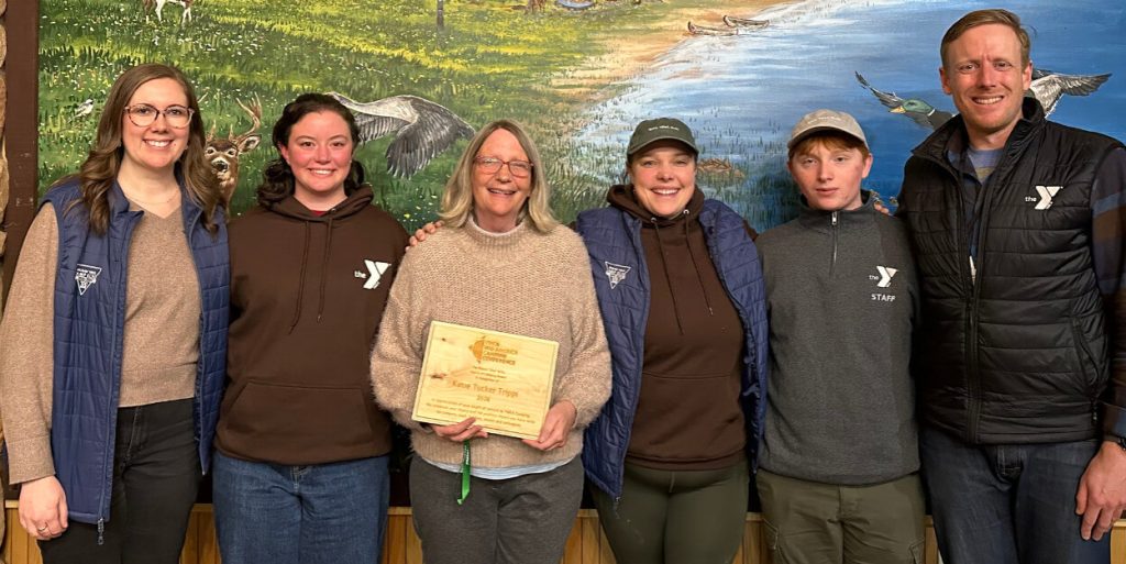 Camp Echo staff and supporters stand with Katie Trippi (center) as she holds her award.