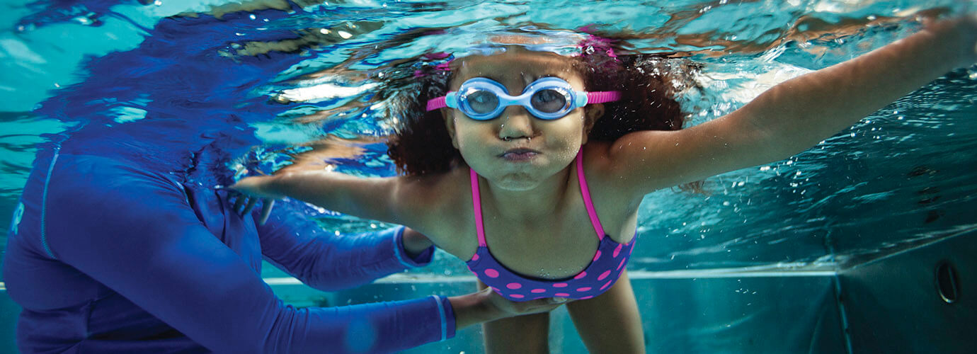 Young girl in pool learning to swim
