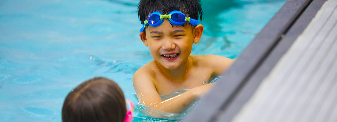two youth in a pool learning to swim