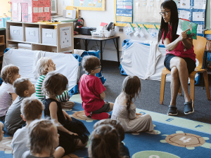 A teacher reads a book to kids at the Children's Center.